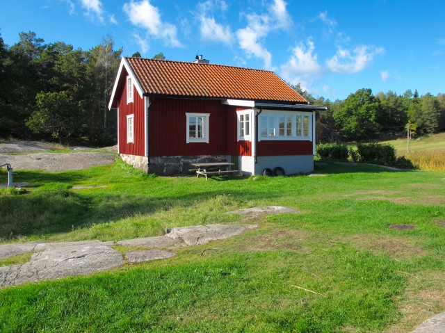 Bild på rött hus med vita knutar.